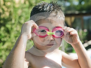 Cute Little Kid with Goggles laughing in Pool