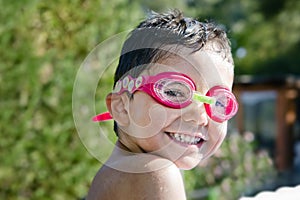 Cute Little Kid with Goggles laughing in Pool