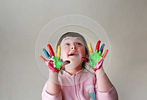 Cute little kid with painted hands. Isolated on grey background