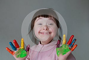 Cute little kid with painted hands. Isolated on grey background