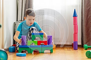 Cute little kid playing with colorful plastic toys or blocks