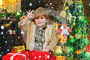 Cute little kids celebrating Christmas. Child in snow. Christmas children. Child with a Christmas present on wooden