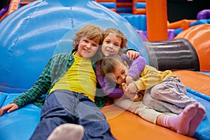 Cute little kids of different age playing on inflatable bounce house