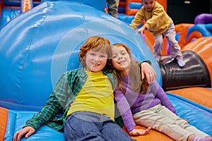 Cute little kids of different age playing on inflatable bounce house