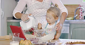 Cute little kitchen helper helping her Mum