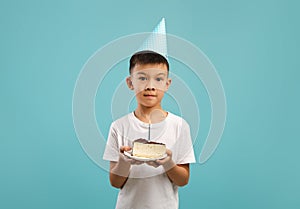 Cute Little Korean Boy Wearing Party Hat Holding Piece Of Birthday Cake