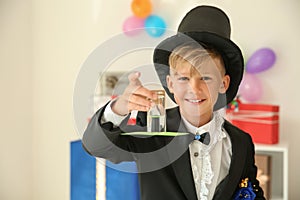 Cute little magician showing trick indoors