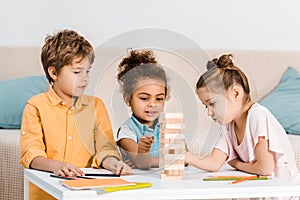 cute little multiracial children playing with wooden blocks