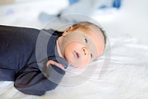 Cute little newborn baby boy lying on a changing table. Portrait of tiny new baby at home