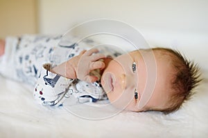 Cute little newborn baby boy lying on a changing table. Portrait of tiny new baby at home