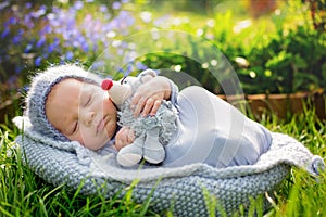 Cute little newborn baby boy, sleeping, holding cute little mouse toy