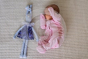 cute little newborn baby girl peacefully sleeps with toy bunny