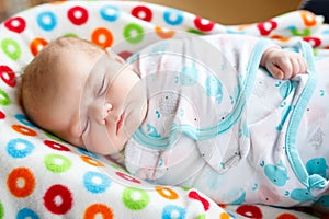 Cute little newborn baby girl sleeping wrapped in blanket