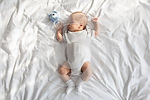 Cute Little Newborn Baby Napping In Bed With Rattle Toy, Top View