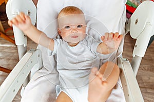 Cute little newborn girl with smiling face looking at camera on white background. Infant baby resting playing lying down