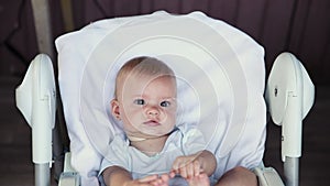 Cute little newborn girl with smiling face looking at camera on white background. Infant baby resting playing lying down