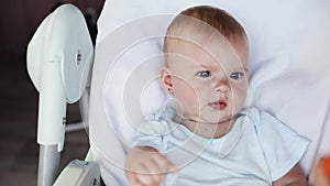 Cute little newborn girl with smiling face looking at camera on white background. Infant baby resting playing lying down