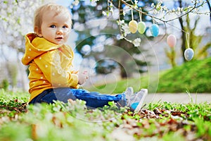 Cute little one year old girl playing egg hunt on Easter