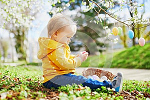 Cute little one year old girl playing egg hunt on Easter