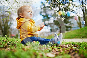 Cute little one year old girl playing egg hunt on Easter