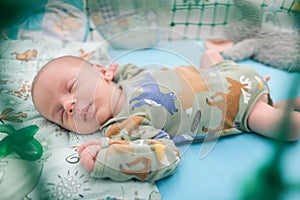 Cute little peaceful baby calm sleeps soundly in his crib in a bright room