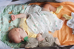 Cute little peaceful baby calm sleeps soundly in his crib with his baby toys in a bright room