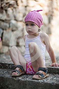 Cute little pensive girl looking for someone or something