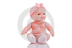 Cute little plastic baby doll with blue eyes sitting isolated o