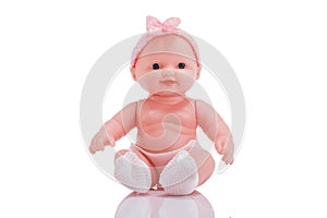 Cute little plastic baby doll with blue eyes sitting isolated o