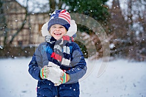 Cute little preschool girl outdoors in winter park . Adorable healthy happy child playing and having fun with snow, outdoors on