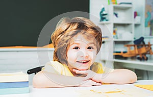 Cute little preschool kid boy with teacher study in a classroom.