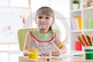 Cute little preschooler child drawing at home