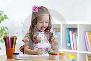 Cute little preschooler child girl drawing color pencils at home or studio