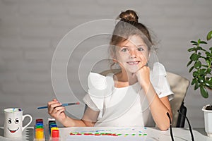 Cute little preschooler child girl drawing at school. Child girl painting on elementary school. Funny kids face.