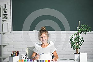 Cute little preschooler child girl drawing at school. Child girl painting on elementary school. Kids creative education