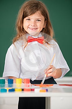 Cute little preschooler child girl drawing at school. Child girl painting on elementary school. Portrait of little girl