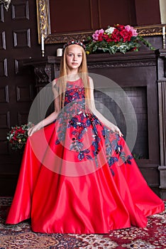 Cute little redhead girl wearing an antique princess dress or costume.