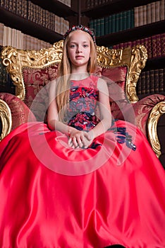 Cute little redhead girl wearing an antique princess dress or costume.