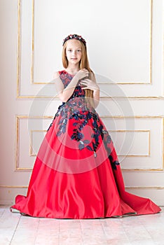 Cute little redhead girl wearing an antique princess dress or costume.