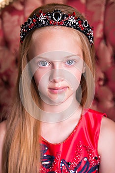 Cute little redhead girl wearing an antique princess dress or costume.