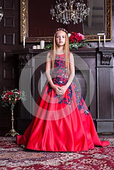 Cute little redhead girl wearing an antique princess dress or costume.