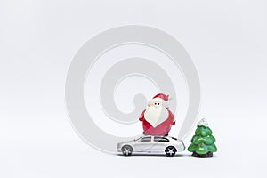Cute little Santa claus doll on model car and Christmas tree isolate on white background