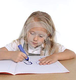 Cute little schoogirl happy on desk drawing on notepad with marker