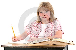 Cute Little School Girl Sitting in Desk with Books