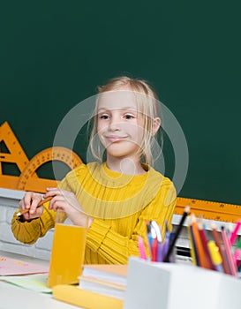 Cute little school kid girl study in a classroom. Genius child, knowledge day. Kids education and knowledge.