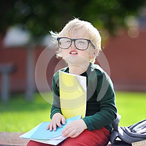 Cute little schoolboy studying outdoors on sunny day. Back to school concept.