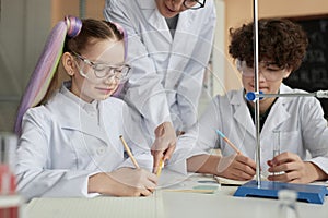 Cute little schoolgirl doing science experiment in school classroom