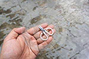 cute little scissors for kids playing. Small scissors on adult hand