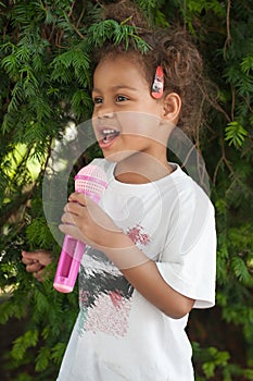 Cute little singer girl singing on the microphone in the city pa