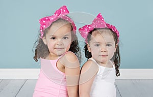 Cute little sisters in pink headbands